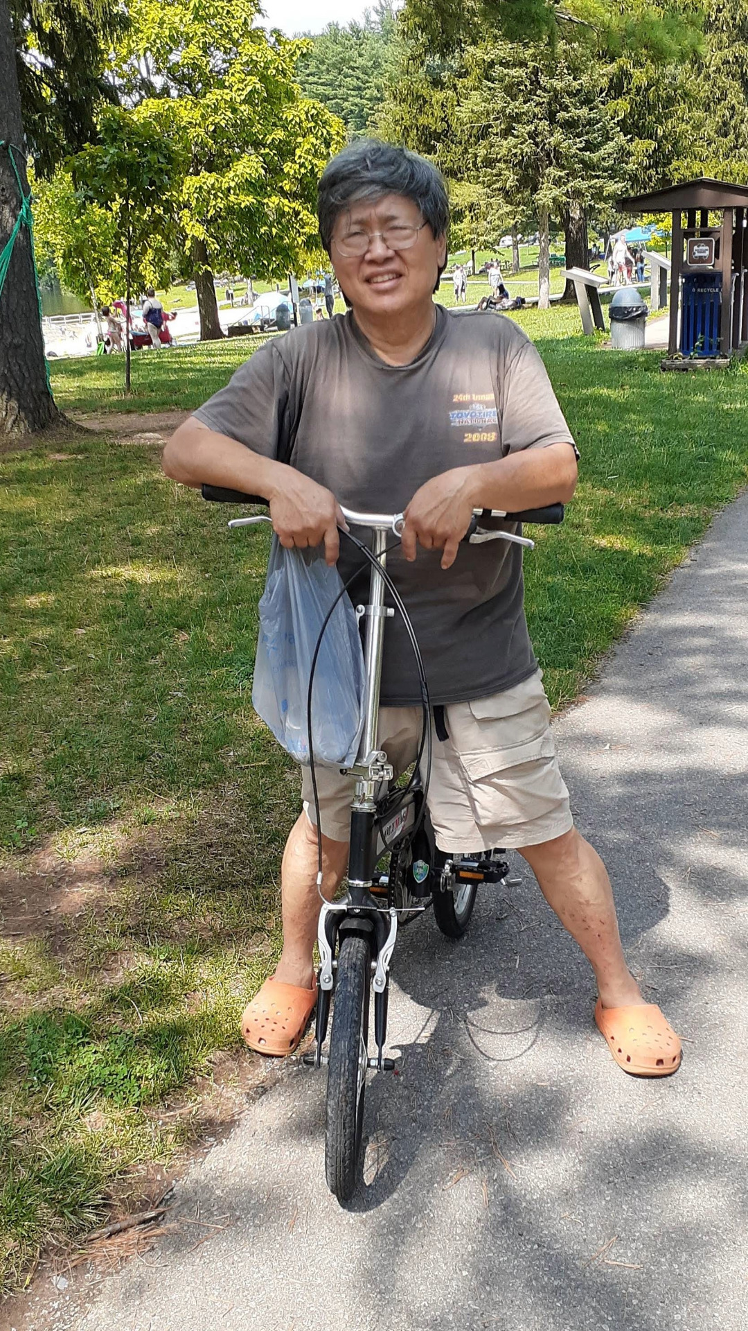 George Hing with his folding bike stopped along a path in the park